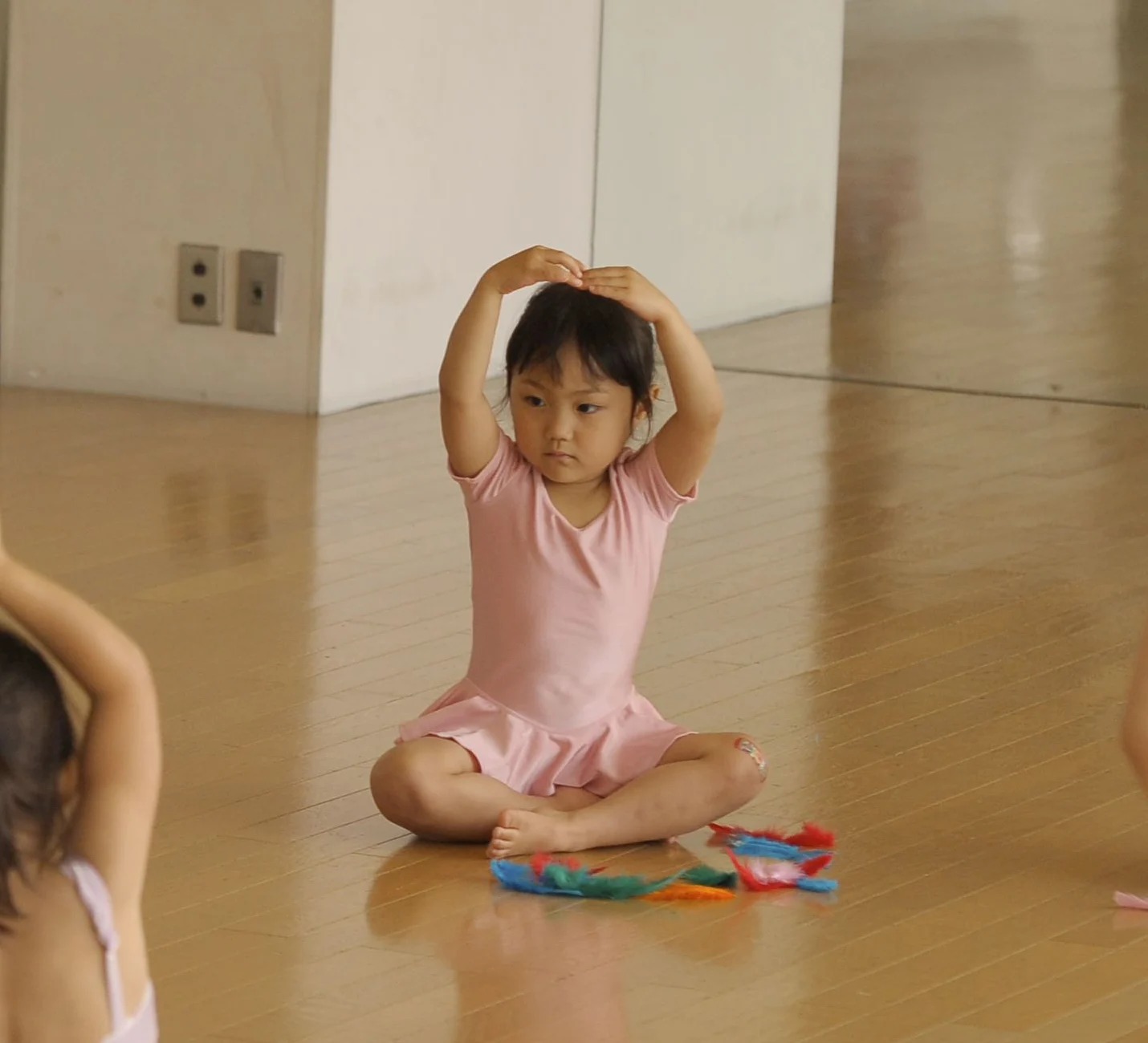 M studioのレッスンでスカーフを頭上に掲げる3〜4歳の子ども